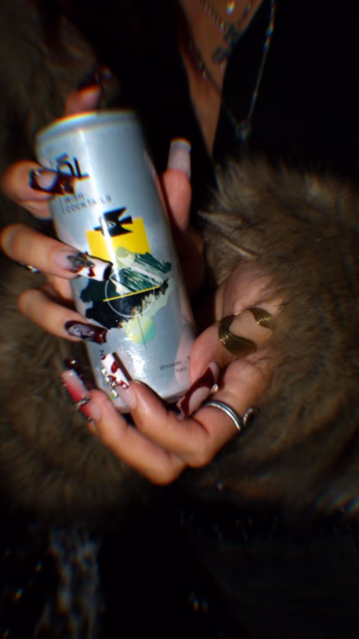 A woman with long nails holding a can of Ól Irish Cocktail